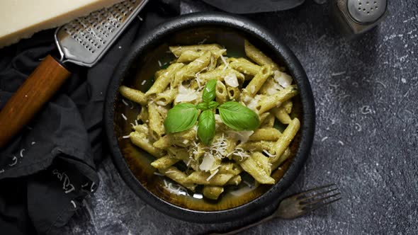 Pasta with Parmesan Cheese and Creamy Pesto Sauce in Black Bowl