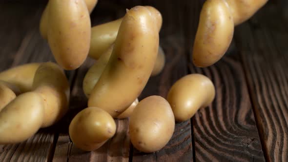 Super Slow Motion Shot of Potatoes Rolling on Old Wooden Table at 1000Fps alt