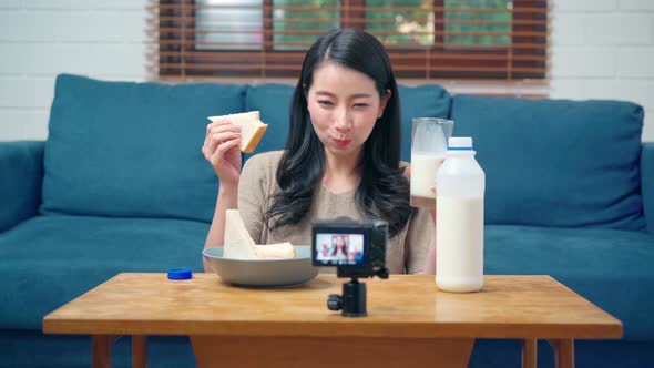 Asian women using camera streaming and recording vlog video about the benefit for broadcast online. alt