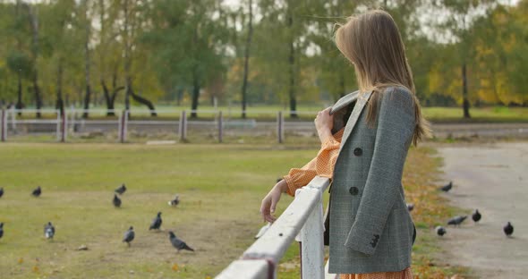 Side View of an Attractive Caucasian Woman with Long Brown Hair Standing Next To the Corral alt