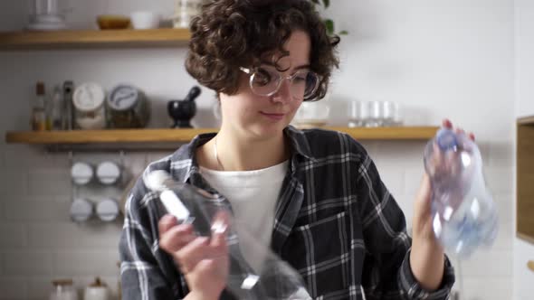 Concept Of Recycling, Waste Sorting. Girl Manually Sorts, Throws Plastic Bottles In Trash Can alt