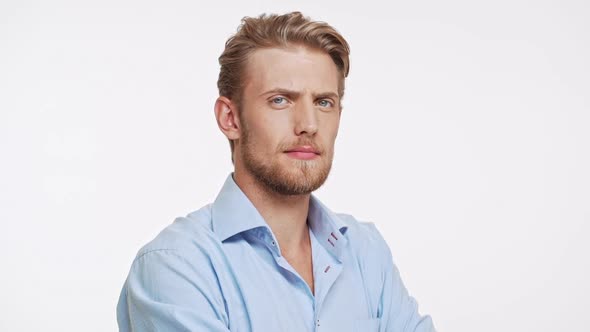 Serious Young Caucasian Male with Blue Eyes and Brown Beard Approves on White Background in alt