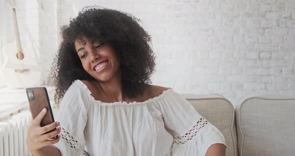 Happy Afro Black Woman Looking at Mobile Phone Waving Hand and Greeting