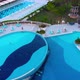 Flight Over the Beach with Umbrellas Towards the Pool in a Luxury Hotel - VideoHive Item for Sale