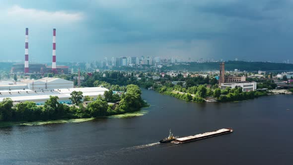 Aerial View of River Tugboat Towing Barge Carrying Freight to Port alt