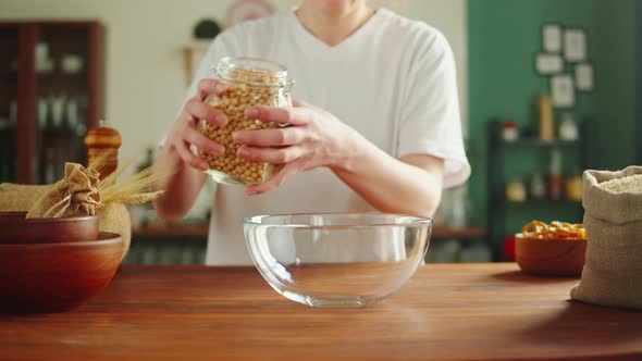 Grocery Putting Chickpeas in Bowl Closeup alt