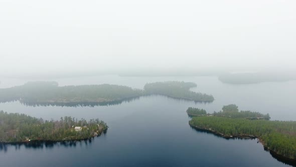 Aerial shot of islands with forest, calm lake and small settlement in Willard Lake, Ontario, Canada alt