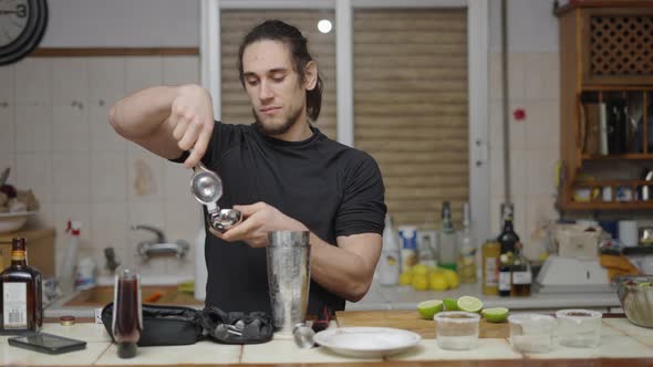 Focused Barman Squeezing Limes for Cocktail Juice in Kitchen Countertop alt