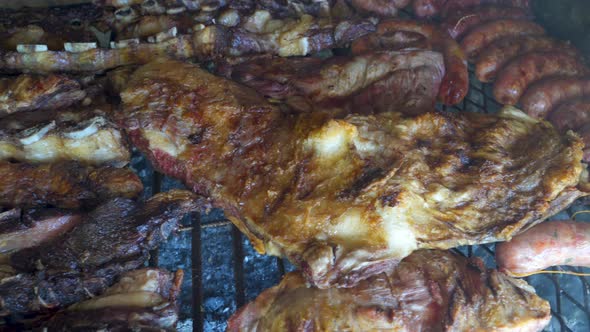 Close up shot of crispy and roasted pieces of chicken and beef in Argentinian asado alt