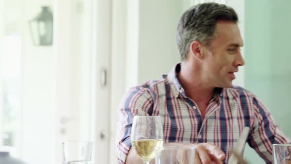 Family interacting while having meal on dining table alt