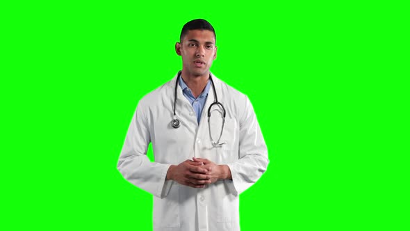 a mixed race man wearing a surgeon blouse and scrumbs in a green background