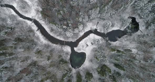 Heart Shape Spring Water Lake Connected to River in Snowy Forest Aerial View alt