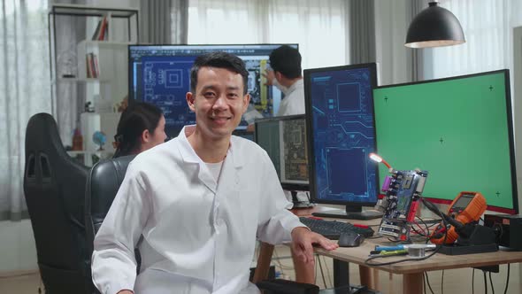 Asian Man Smiling Charmingly Looking At Camera. Young Intelligent Male Scientist Working In Office alt