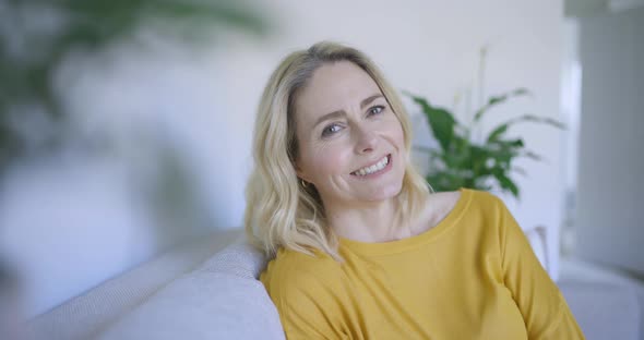 Cofident woman sitting on couch, smiling alt