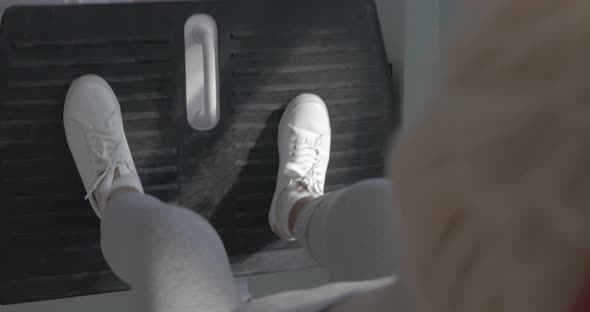 Senior woman exercising on fitness machine alt