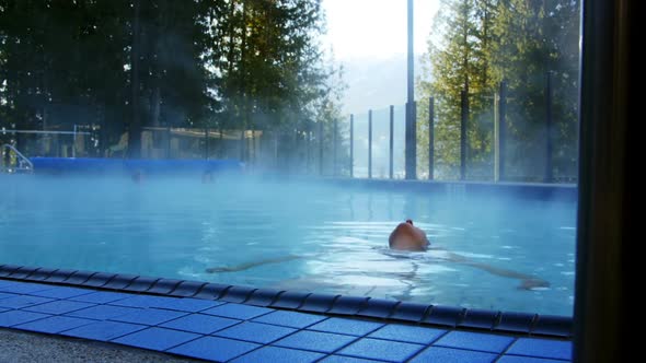 Woman relaxing in swimming pool alt