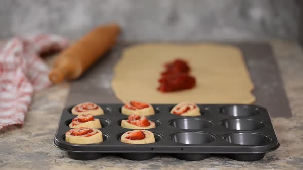 Female Hands Making Buns with Berry Jam. alt