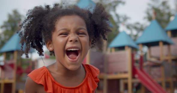 Medium Shot of Cute Afroamerican Little Girl Yelling on Playground alt