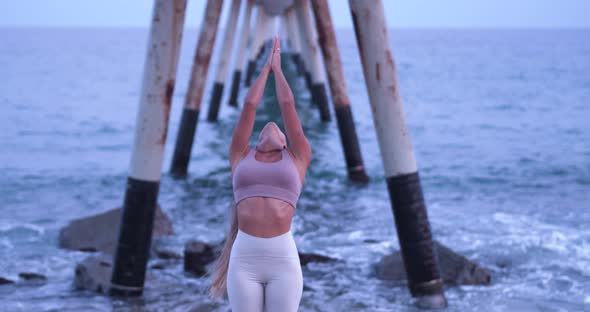 Young Latin Woman Practicing Yoga on the Beach During a Sunset alt