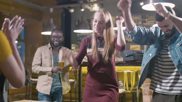 Excited couple playing tabletop soccer with friend