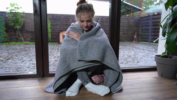 Wide Shot Relaxed Happy Teenage Girl Wrapped in Blanket Smiling Enjoying Leisure at Home on Rainy alt