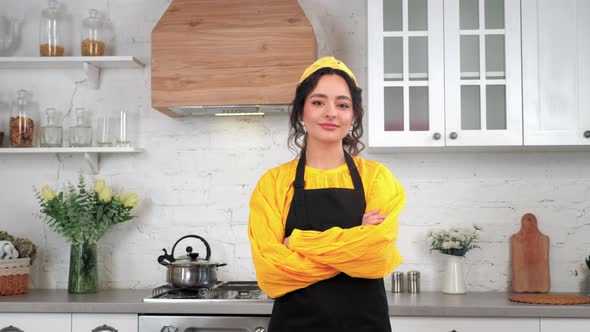Portrait Smiling Housewife Looking Camera with Crossed Hands in Home Kitchen alt