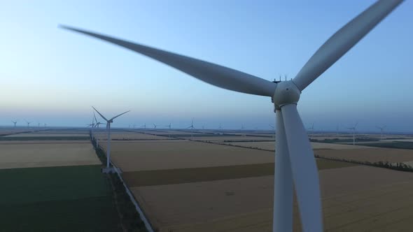 Wind Turbines in Fields Near the Sea Driven with the Sea Breeze, Aerial Survey, Close Up alt