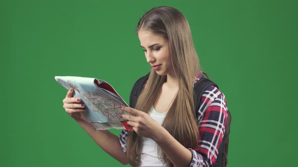 Happy Young Beautiful Woman Tourist Backpacker Smiling Looking at the Map alt