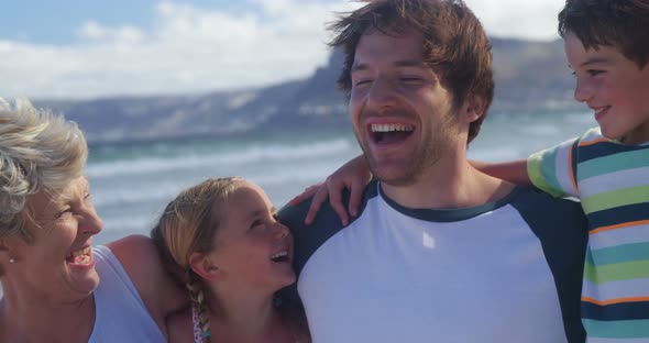 Multi generation family enjoying at beach alt