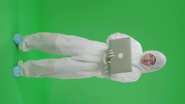 Full Body Of Asian Man Wear Uniform Ppe Holding And Working With Laptop In The Green Screen Studio alt