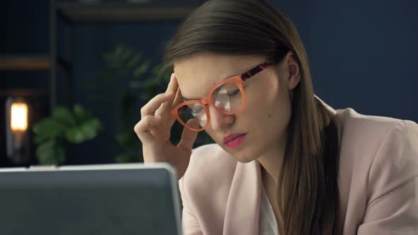 Close Up Portrait of a Beautiful Serious Woman in Glasses Working at a Laptop