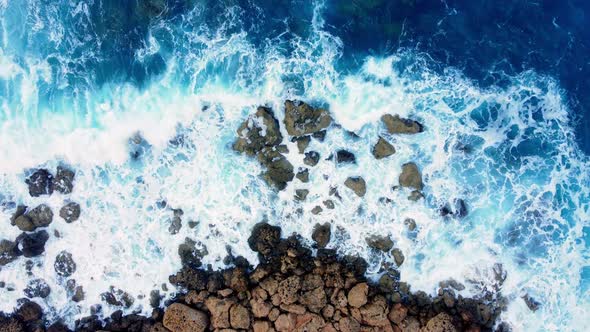 Sea Waves Washes the Rocky Shore Above Aerial Shot Flying Over Coastline Cliffside with Blue Pure alt