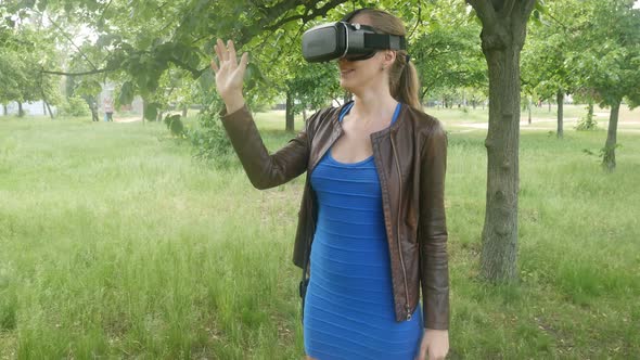 Beautiful Cheerful Woman Uses A Modern Helmet Of Virtual Reality On The Nature
