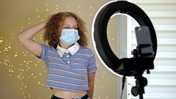 Cheerful Teen Girl Dancing at Camera in a Medical Mask Filming Video Creating Her Trendy Content on alt