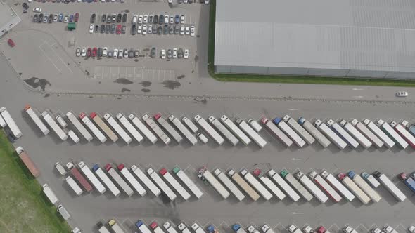 Logistic warehouse parking lot with many semi trucks with cargo trailers waiting  alt