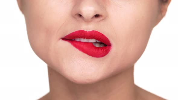 Extreme Close Up Portrait of Smiling Female Person 30s Biting Her Lower Lip Covered with Red Matte alt