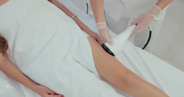 Closeup of the Apparatus Massages Legs and Hips of Young Female alt