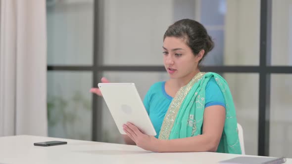 Indian Woman Making Video Call on Tablet in Office alt