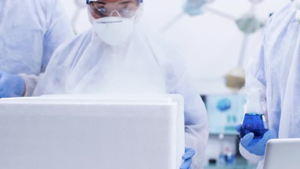 Handheld Footage of Amazed Female Scientist Opening a Chemical Refrigerator Box in Modern Laboratory alt