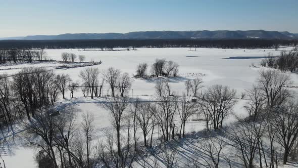 Mesmerizing view of Mississippi River in winter. Snow and ice covered water and bare trees.