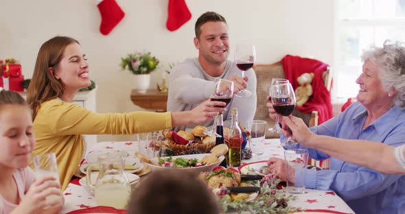Caucasian family toasting while sitting on dining table alt