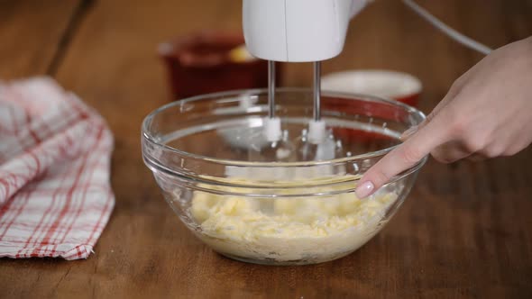 Close Up Of Butter With Sugar Mixing In Glass Bowl alt