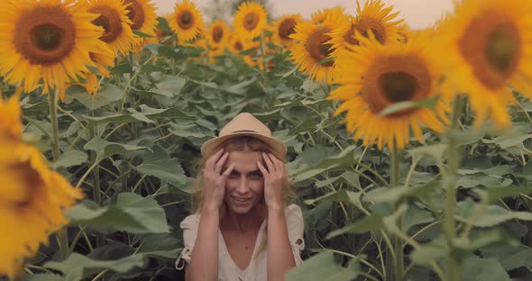 Pretty Girl Walks Among the Tall Sunflowers and Smiles She is Happy