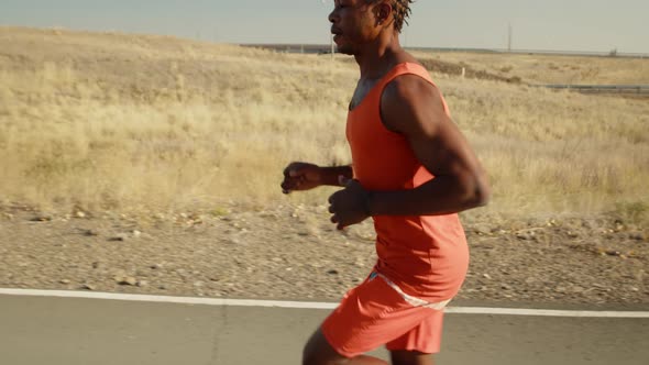 Black Man is Engaged in Daily Training Run Checks His Pulse on Smart Watch Side View alt