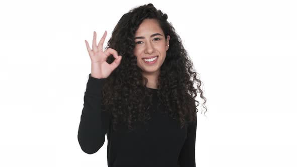 Portrait of Charming Curly Long Haired Adult Girl Happily Showing Thumb Up Isolated on White alt