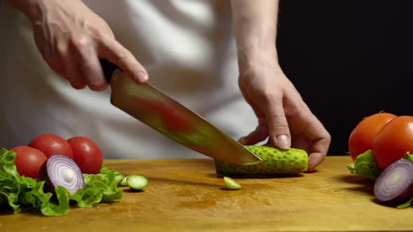 Woman Cuts Green Cucumber for Salad