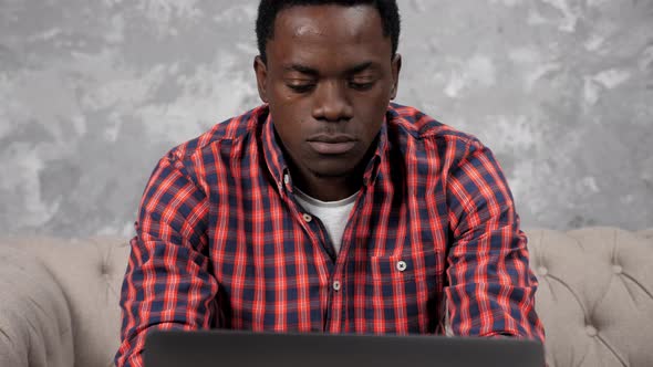 Concentrated African American Businessman Works Laptop Chatting with Employees alt