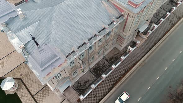 Cars Drive Along Road Near Building with Spire in Old City