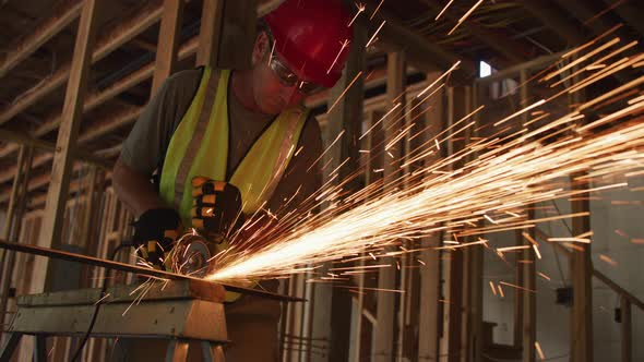 Construction worker grinding metal and making sparks