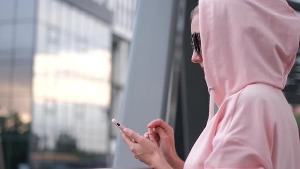 A Young Girl is Dressed in a Pink Jacket She Uses a Smartphone for Notifications alt